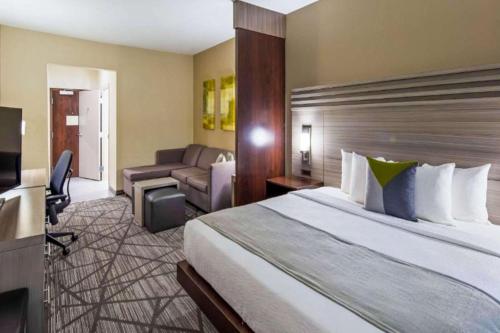 Habitación de hotel con cama grande y escritorio. en Comfort Inn & Suites Houston I-45 North - IAH en Houston