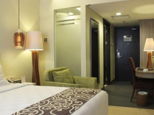 a hotel room with a bed and a desk at BW Kemayoran Hotel & Convention Powered by Archipelago in Jakarta