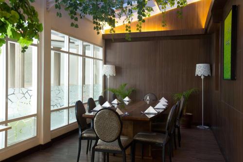 a dining room with a table and chairs and windows at BW Kemayoran Hotel & Convention Powered by Archipelago in Jakarta
