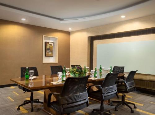 a conference room with a table and chairs and a projection screen at BW Kemayoran Hotel & Convention Powered by Archipelago in Jakarta