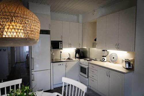 - une cuisine avec des armoires et des appareils blancs dans l'établissement Mukava saunallinen kaksio omalla sisäänkäynnillä ja ilmaisella autopaikalla, à Kuopio