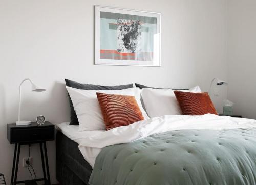 a bedroom with a bed with white and orange pillows at W Apartments Uus-Hollandi with sauna in Tallinn