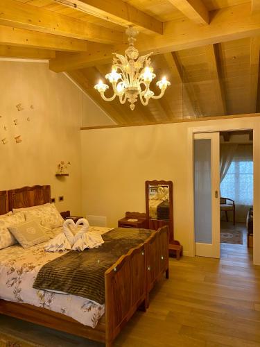a bedroom with a large bed and a chandelier at ROSETO HOLIDAYS AZZURRO in Cavalcaselle