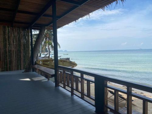 uma vista para a praia a partir de uma varanda do resort em Benjamin's Hut em Srithanu