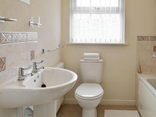 een badkamer met een toilet, een wastafel en een bad bij Acacia in Thornbury