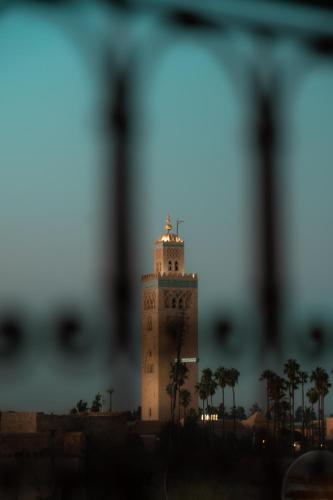 a tall tower with a clock on top of it at Riad Lalla Mimouna in Marrakech