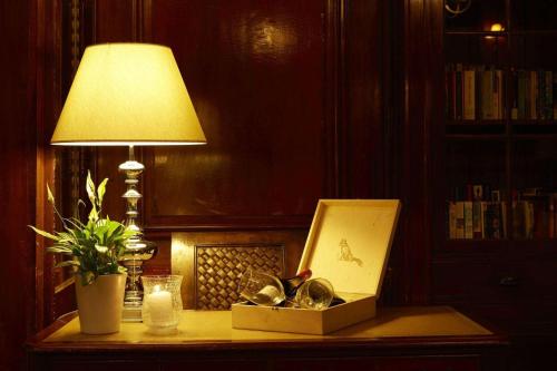 a lamp sitting on a table next to a box of dishes at Mon Repos Palace - Adults Only in Corfu