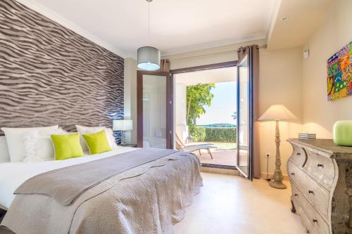 1 dormitorio con 1 cama y puerta corredera de cristal en 2156-Luxury apt in Cortesin golf with pool view, en Casares