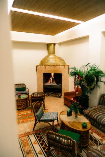 a living room with a fireplace and a table and chairs at Riad Lalla Mimouna in Marrakech