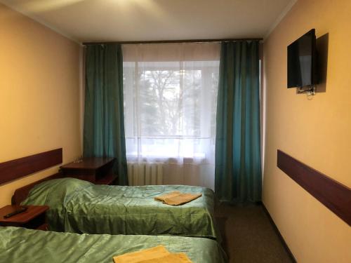 Cette chambre comprend 2 lits et une fenêtre. dans l'établissement Готель Профспілковий, à Vinnytsia