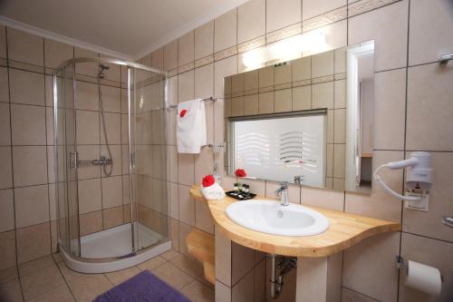 La salle de bains est pourvue d'un lavabo et d'une douche. dans l'établissement Kanakis Apartments, à Asos