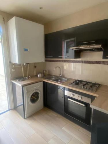 La cuisine est équipée d'un évier, d'une cuisinière et d'un lave-vaisselle. dans l'établissement Puteaux : Appartement spacieux pour 5 personnes, à Puteaux