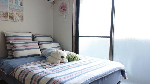 a teddy bear sitting on a bed in a bedroom at JING HOUSE渋谷ダブルベッド/新宿・渋谷駅近 in Tokyo