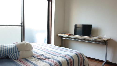 a bedroom with a bed and a tv on a table at JING HOUSE渋谷ダブルベッド/新宿・渋谷駅近 in Tokyo