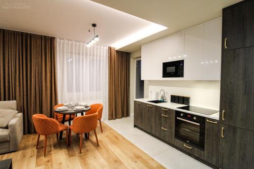 Il comprend une cuisine et un salon avec une table et des chaises. dans l'établissement D Apartments Centrum Ziemia, à Białystok