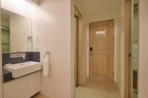 a bathroom with a sink and a mirror and a door at The Tides Hotel Boracay in Boracay