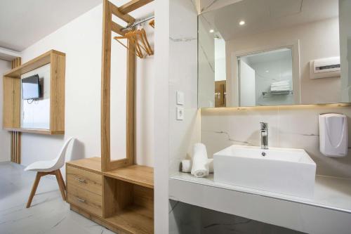 een badkamer met een wastafel en een spiegel bij Venezia Resort Hotel in Faliraki
