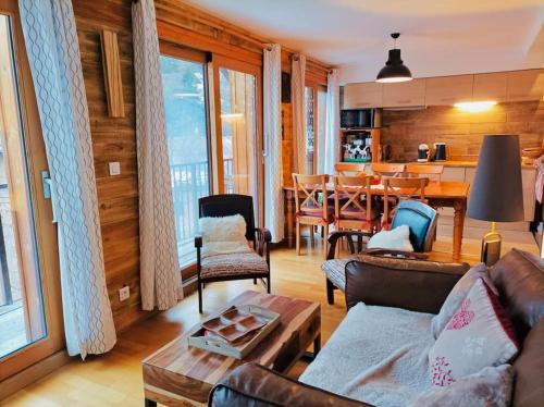 un soggiorno con divano e tavolo di Le Coucou - Grand chalet - Parking - WIFI - ALLOS - 10adul+2enf ad Allos