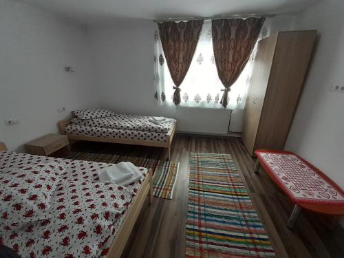 a bedroom with two beds and a window at Cabana Colț de Rai in Arieşeni