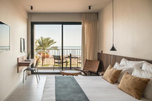 a hotel room with a bed and a balcony at Lindos Aqua Terra in Líndos