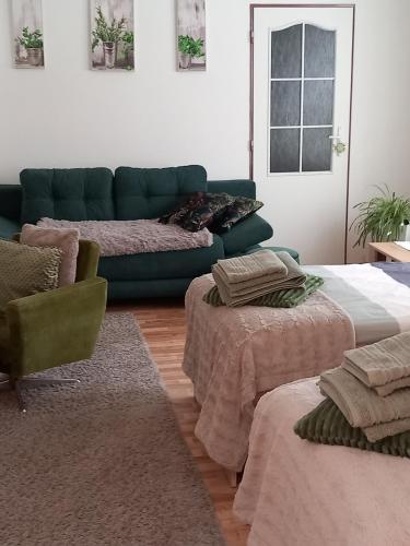 un soggiorno con 2 letti e un divano verde di Kapitula centrum a Banská Bystrica