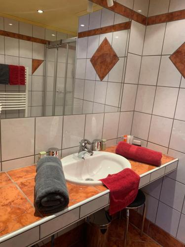 un baño con lavabo y toallas rojas en una encimera. en Appartements Gästehaus Schrott, en Oetz