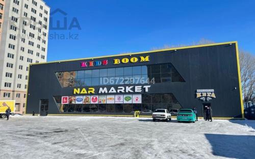 ein großes Gebäude mit Autos auf einem Parkplatz in der Unterkunft Чувствуй себя как дома!!! in Öskemen