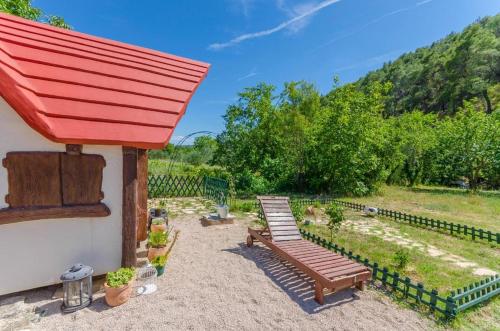 a backyard with a bench and a red roof at Krka Fairytale village in Rupe