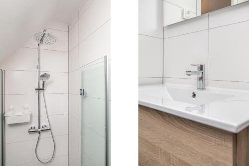 uma casa de banho branca com um chuveiro e um lavatório. em VILLA ARYVE in See-, Strand- und Golfplatznähe inklusive NETFLIX, Bad en Suite und Wohlfühlgarantie em Dirkshorn