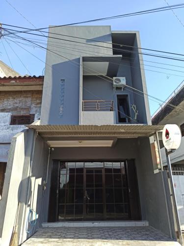 a blue building with a door in front of it at Ganjar Homestay in Sentool