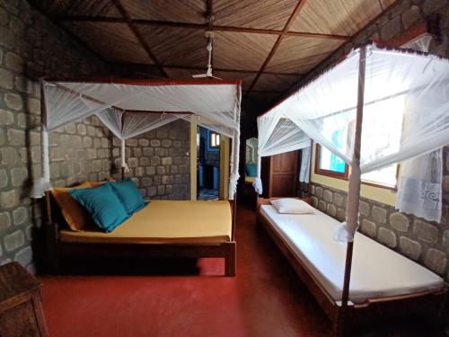 een slaapkamer met 2 bedden in een tent bij VILLA LA RUCHE - Iles aux nattes in Ile aux Nattes