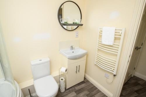 een badkamer met een toilet, een wastafel en een spiegel bij Pass the Keys Homey flat in Sleaford Centre in Sleaford