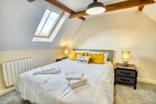 een slaapkamer met een groot wit bed met gele kussens bij Pass the Keys Homey flat in Sleaford Centre in Sleaford