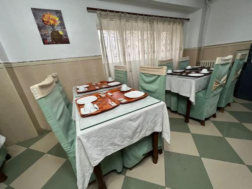 jadalnia ze stołami i krzesłami z talerzami i jedzeniem w obiekcie Le cheval blanc w mieście Oran