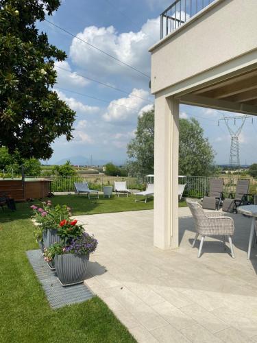 a patio with chairs and flowers in a yard at ROSETO HOLIDAYS AZZURRO in Cavalcaselle