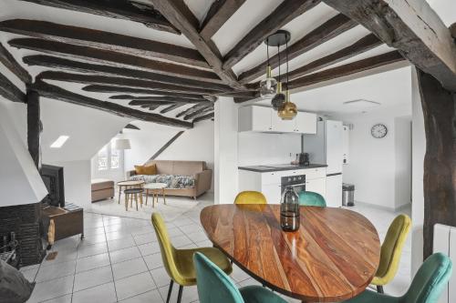 - une salle à manger et un salon avec une table et des chaises en bois dans l'établissement Le Montreuil- Versailles, à Versailles