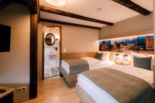 a hotel room with two beds and a sink at Hotel Einbecker Hof in Einbeck