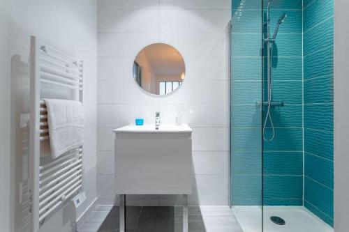 een badkamer met een wastafel en een douche met een spiegel bij Vieux Port : Le Pavillon in Marseille