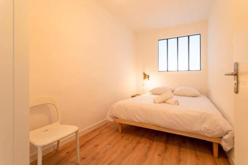 a white bedroom with a bed and a window at Vieux Port : Le Pavillon in Marseille