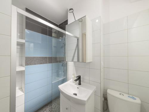 uma casa de banho branca com um lavatório e um WC em Sliska apartment Warsaw em Varsóvia