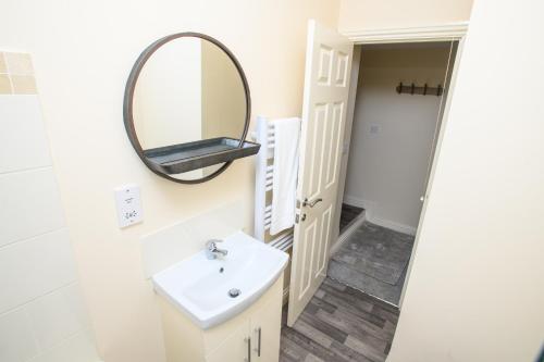 uma casa de banho com um lavatório e um espelho em Pass the Keys Cosy flat in the Town Centre em Sleaford