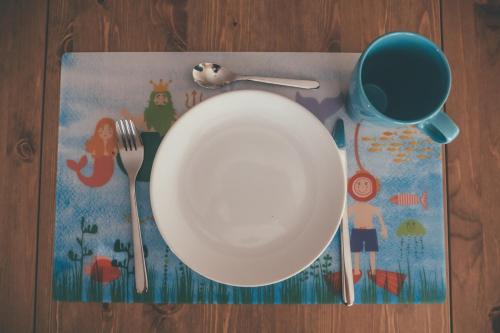 a plate and utensils on top of a table at Oportocean Hostel in Matosinhos