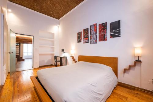 um quarto com uma grande cama branca e uma escada em CasaCasalis - Immersi nella Torino Liberty em Turim