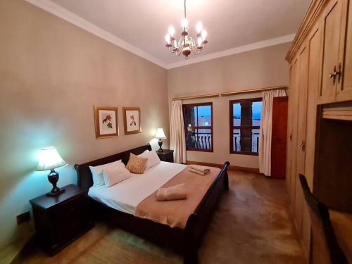 a bedroom with a bed and two lamps and a chandelier at Stone Castle, Dullstroom Country Estate in Dullstroom