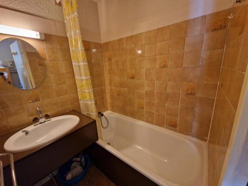 ein Badezimmer mit einem Waschbecken, einer Badewanne und einem Waschbecken in der Unterkunft Boost Your Immo Risoul Le Diamant 823 in Risoul