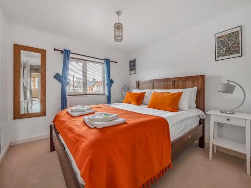 um quarto com uma cama grande com lençóis laranja em Pass the Keys Stylish 2BR Apartment Parking x 2 Oxford em Oxford