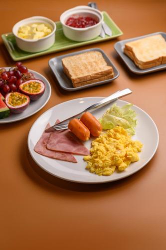 a table with a plate of food with breakfast foods at Estia Chiangmai in Chiang Mai