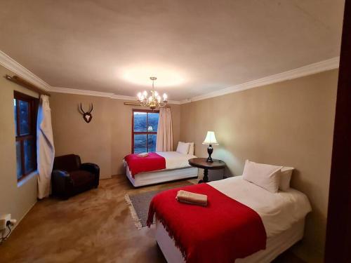 a bedroom with two beds and a chair and a window at Stone Castle, Dullstroom Country Estate in Dullstroom