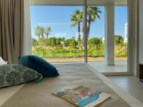 a book and pillows on a bed with a window at Marelive - CDSHotels in Torre dell'Orso