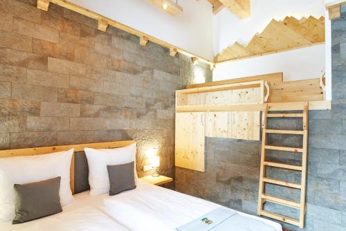 a bedroom with a bunk bed and a ladder at Alpenlandhaus Alte Schule in Lermoos